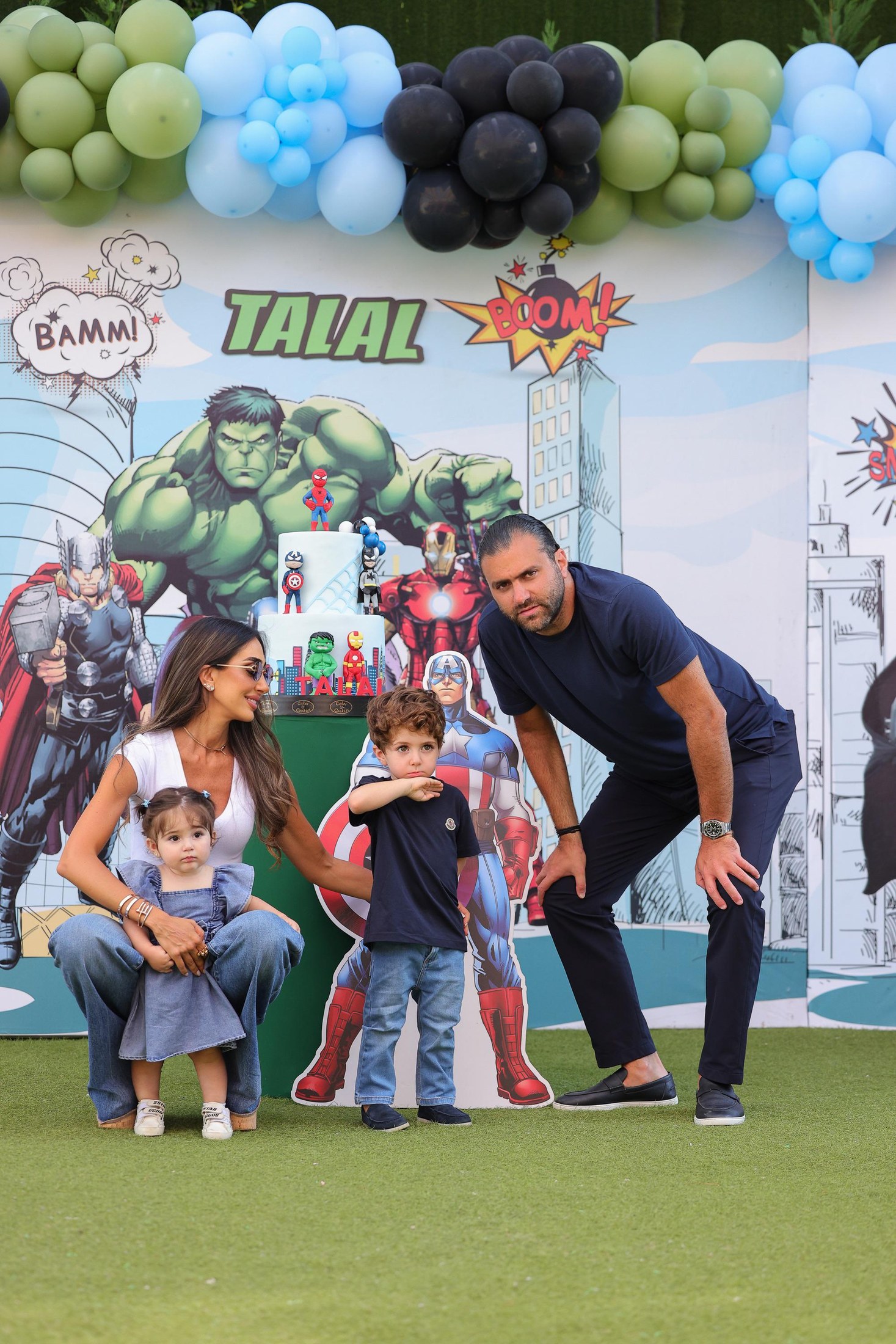 A family birthday moment at Recreo with balloons, cake, and superhero artwork