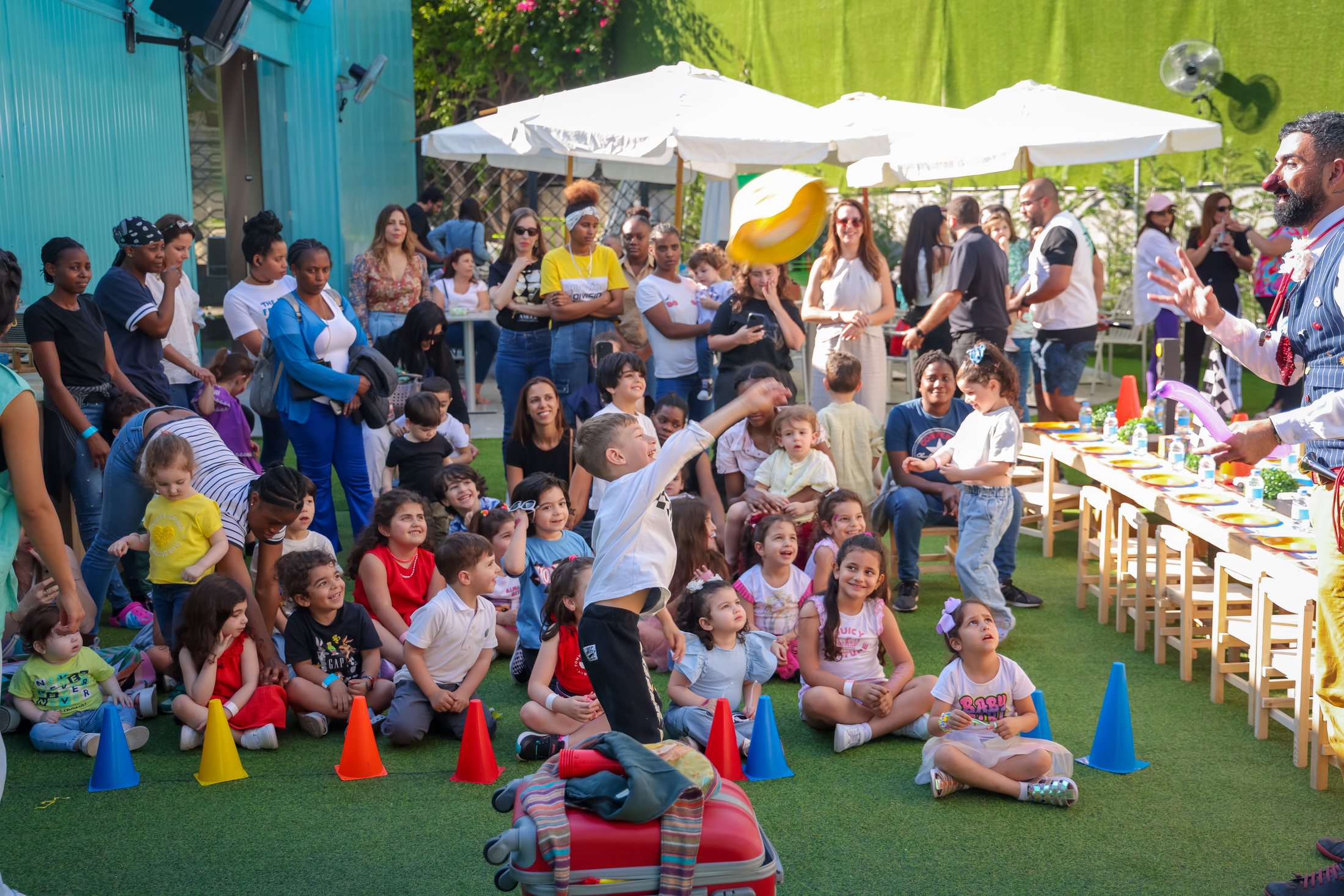 Families gathered outdoors at Recreo during an interactive show moment
