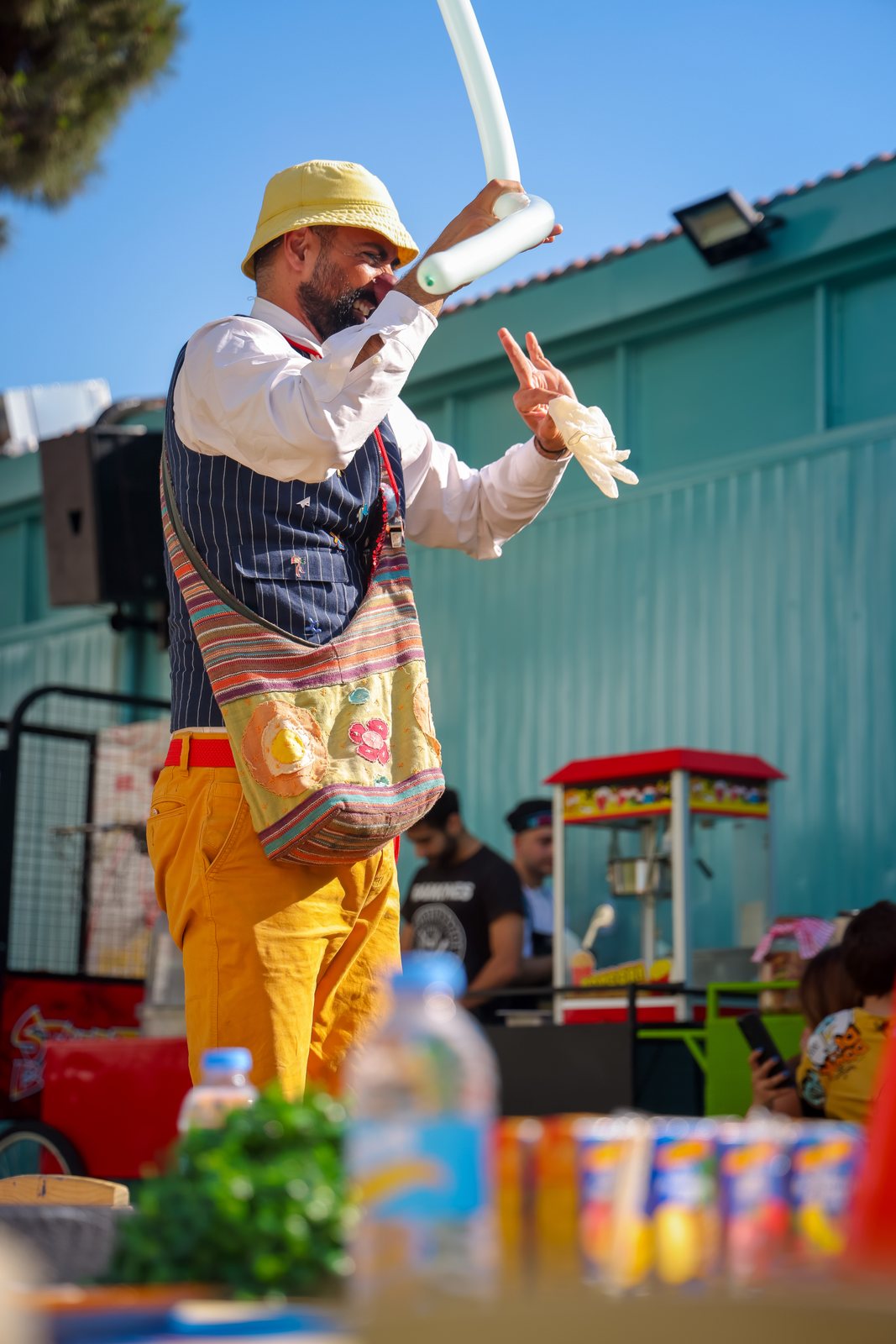 A Recreo performer creating a balloon activity beside the play area
